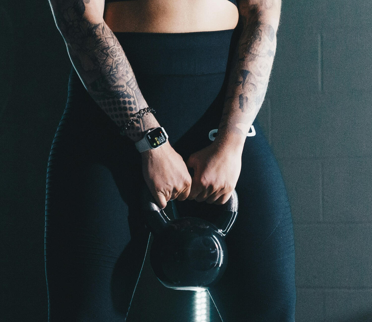 Yoga Instructor squatting and holding a weight