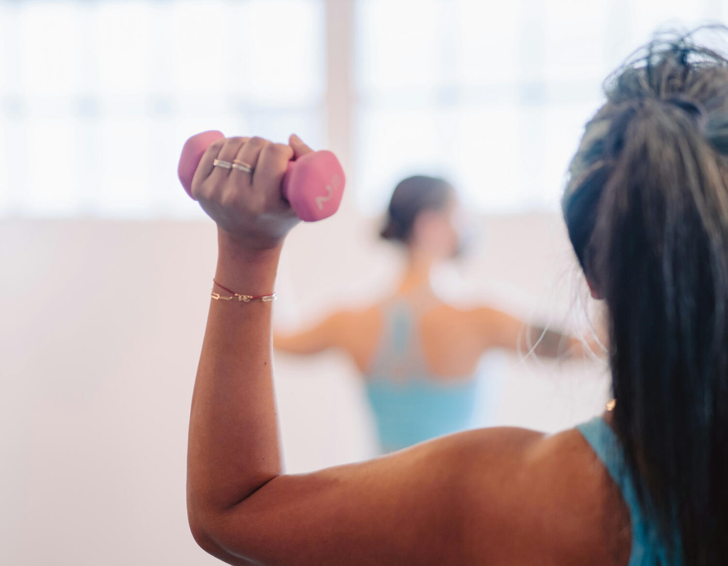 Yoga Kendra Malmö Barre/ Pilate Woman in yoga clothes holding small weights in each hand